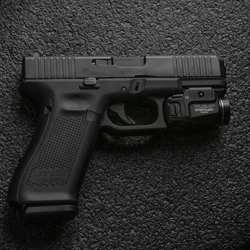 black semi automatic pistol on gray textile